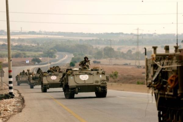 Israeli soliders ride in their armoured vehicles towards the border with the Gaza Strip on October 16, 2023, amid the o<em></em>ngoing battles between Israel and the Palestinian group Hamas. Thousands of people, both Israeli and Palestinians have died since October 7, 2023, after Palestinian Hamas militants ba<em></em>sed in the Gaza Strip, entered southern Israel in a surprise attack leading Israel to declare war on Hamas in Gaza on October 8. (Photo by Menahem KAHANA / AFP) (Photo by MENAHEM KAHANA/AFP via Getty Images)