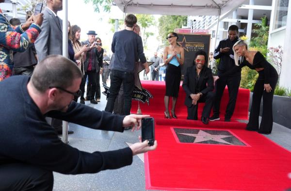 Channing Tatum, far left, takes a picture of Zoe and Lenny Kravitz during his walk of fame ceremony.