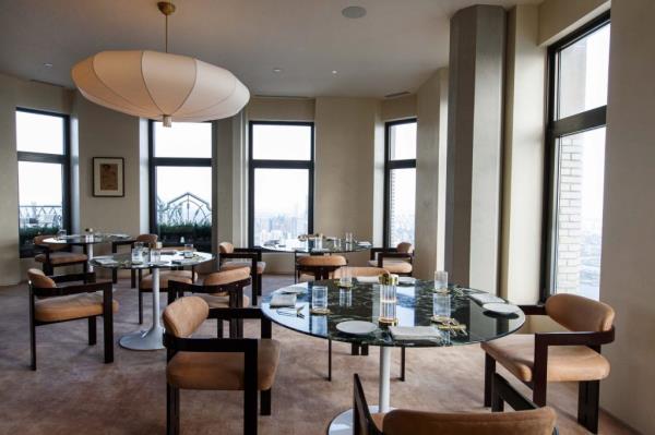 Inside view of the new SAGA restaurant in the Financial District of New York, featuring tables and chairs layout.