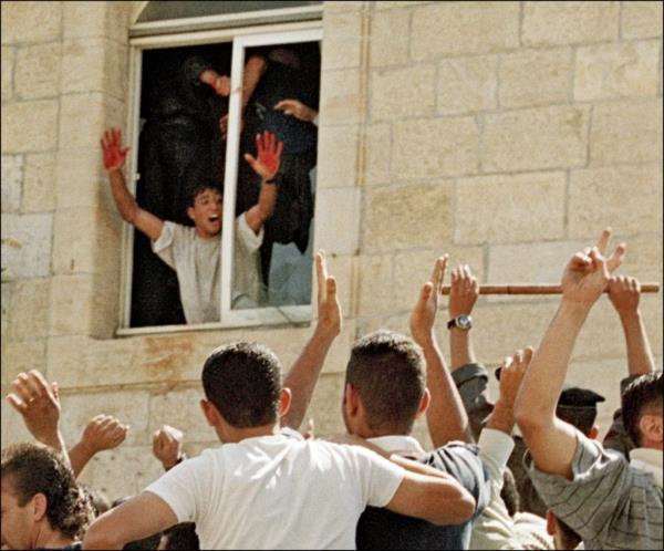 A Palestinian showing his red hands after two Israeli reservists were lynched by a mob in Ramallah on Oct. 12, 2000.