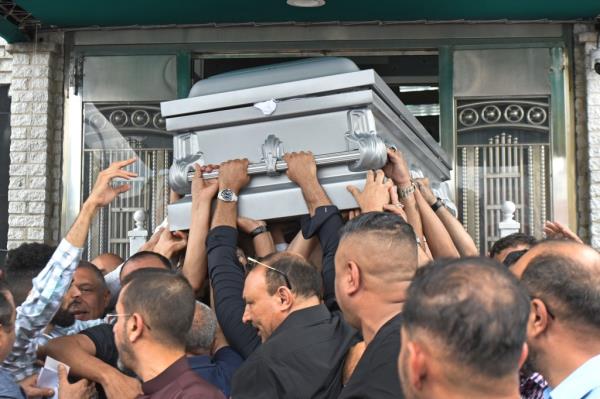 Funeral mourners handling Homod Ali Saeidi's casket. 