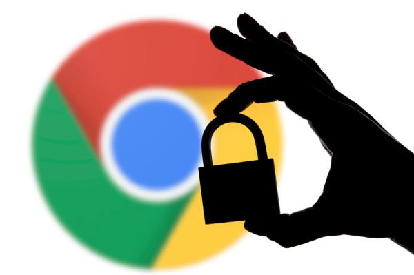 Silhouette of hand holding a padlock in front of Google Chrome logo, symbolizing security issues