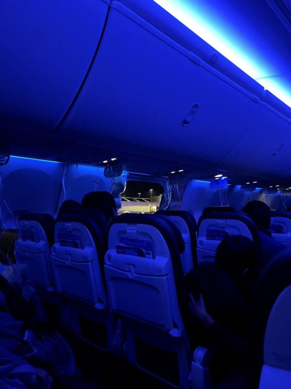 Passengers on the Alaska Airlines flight sit on the runway after the emergency landing. 