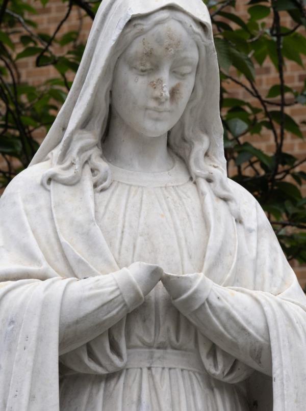 Close up of the vandalized statue of Mary missing her hands