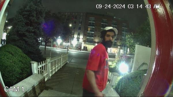 A surveillance video f<em></em>rame of the suspect wearing a red shirt and ba<em></em>seball hat outside of the church