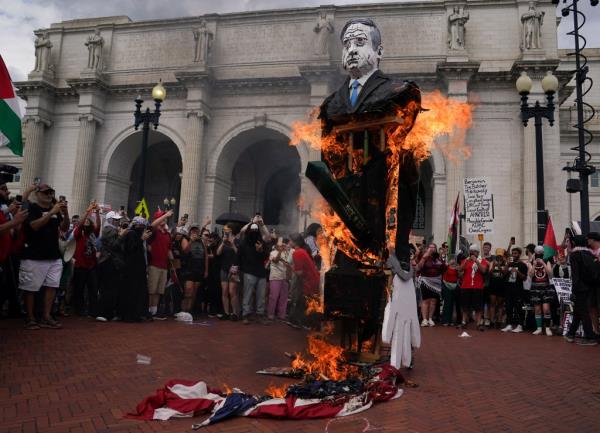 Anti-Israel demo<em></em>nstrators burn a U.S. flag and an effigy depicting Israeli Prime Minister Benjamin Netanyahu, on the day of Netanyahu's address to a joint meeting of Congress, on Capitol Hill in Washington.