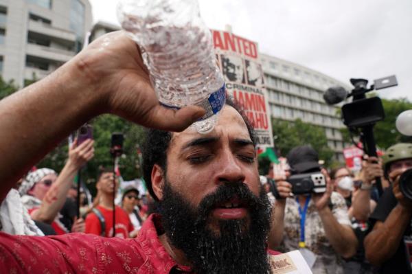 A protester pouring water on himself after getting pepper-sprayed.