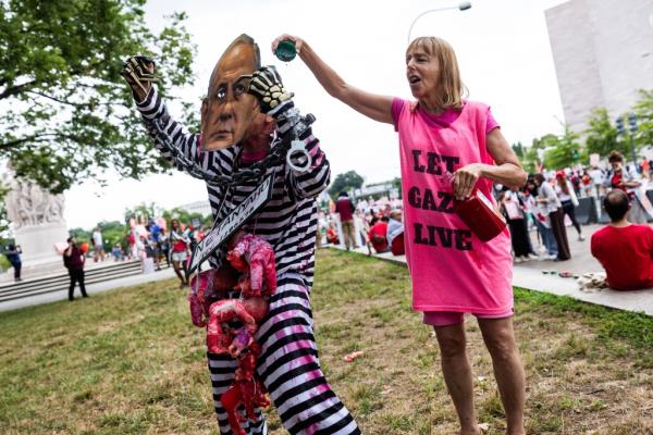 A protester dressed as Netanyahu wearing a priso<em></em>ner uniform.