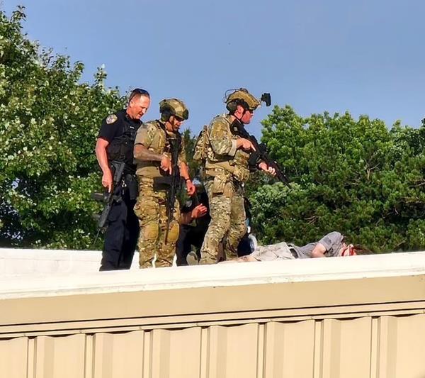 Officers stand over the body of shooter Thomas Matthew Crooks after an assassination attempt on former President Do<em></em>nald Trump during a campaign rally in Butler, PA.