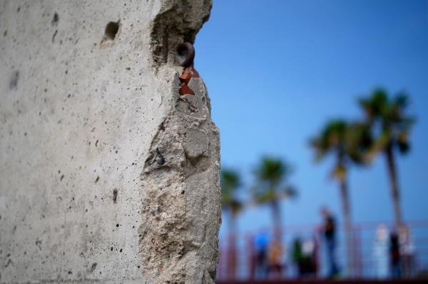 A slab of the Berlin Wall is displayed near the border wall separating the United States from Mexico, in Tijuana, Mexico, Friday, Aug. 25, 2023.