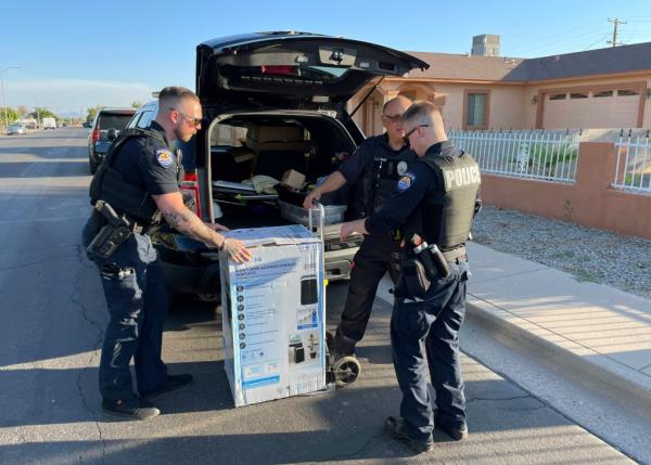 Police Department officers deliver an an air co<em></em>nditioner purchased for two elderly sisters, Paula Martinez, 93, and Linda Martinez, 87, they found sweltering inside their old home in 114 degrees F.