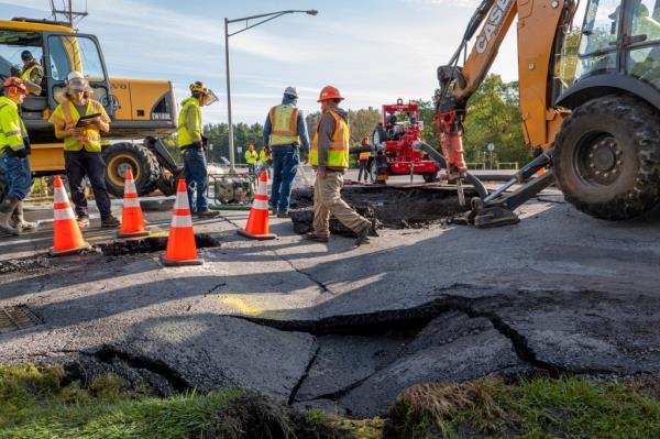 Workers at the scene of a water main rupture in Watertown, New York on October 19, 2023.