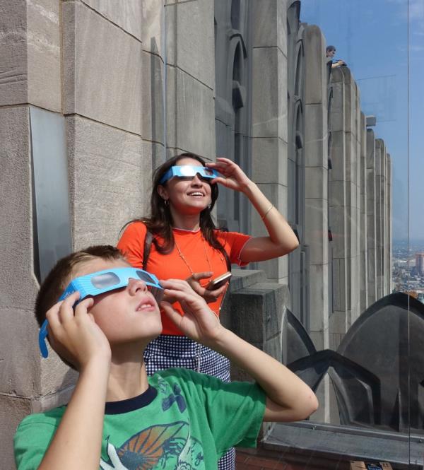 Emilio Sanducci, 8, of Dyker Heights, and Christina Garcia, of Forest Hills, view a solar eclipse in this view from Top of the Rock Monday, Aug. 21, 2017
