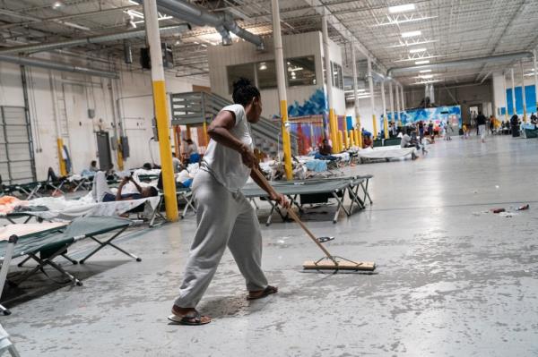 Migrant in sweatpants cleans the floor 
