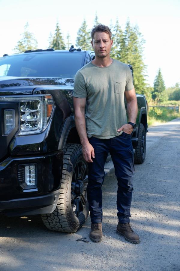 Justin Hartley standing by a truck. 