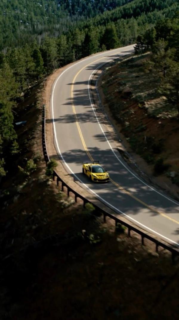 Yellow 2025 Chevy Corvette driving on a road.
