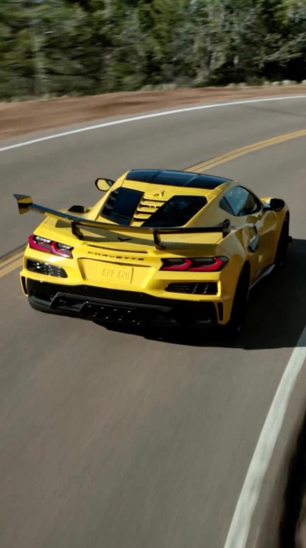Yellow 2025 Chevrolet Corvette ZR1 driving on a road.
