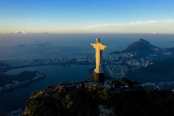The sun rises in front of the Christ the Redeemer statue in Rio de Janeiro on March 24, 2021.