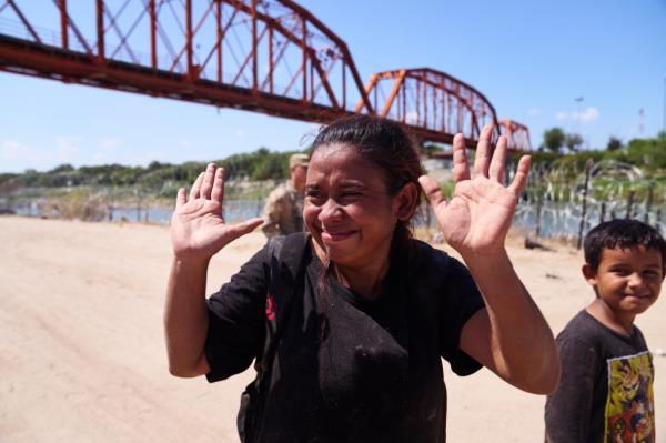 a female migrant waving 