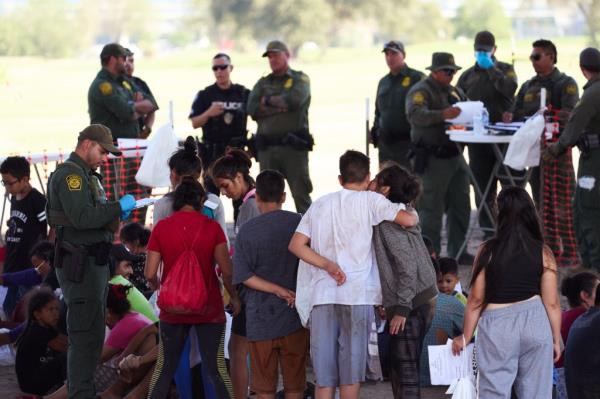 migrants and border officers standing 