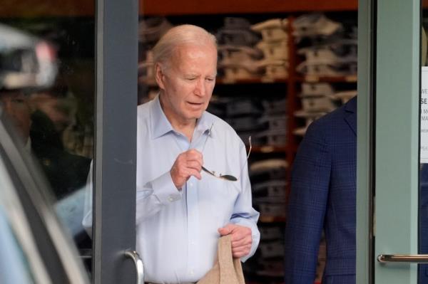 President Joe Biden exiting Jos. A. Bank men's clothing store in Greenville, Del., holding sunglasses, on the evening of May 25, 2024.