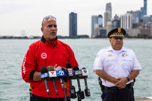 Chicago Police Department Lt. Jose Mendez looks on while Chicago Fire Department Deputy District Chief Jason Lach talks a<em></em>bout the deadly crash.