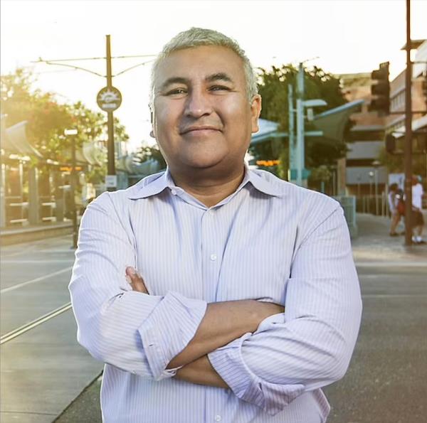 CEO Ernesto Fo<em></em>nseca of Hacienda Community Development Corporation standing on a street with his arms crossed.