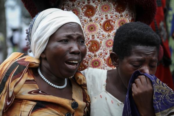Relatives grieve as they wait to collect the bodies of villagers who were killed.