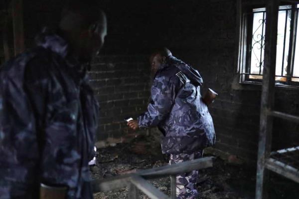Uganda security forces are seen at the premises of an attack in Mpondwe, Uganda, on June 18.