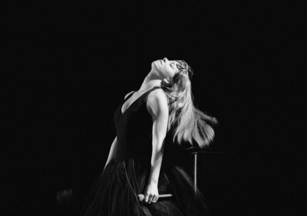 Mariah Carey performs on stage in a long black dress at Wembley Arena in Lo<em></em>ndon in 1996.