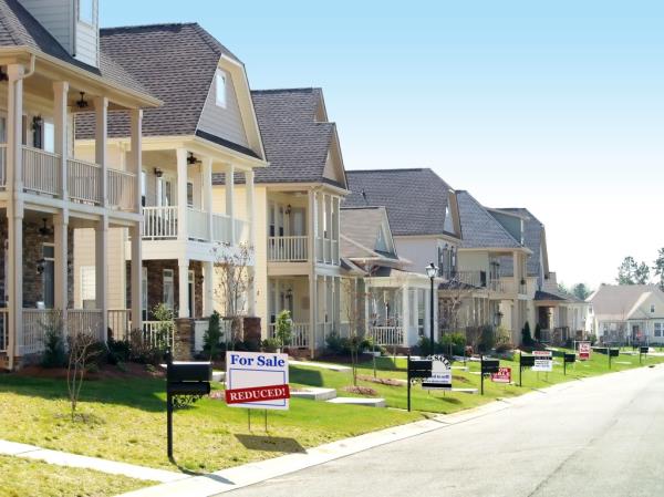 Row of nice homes on a street, all of them for sale.