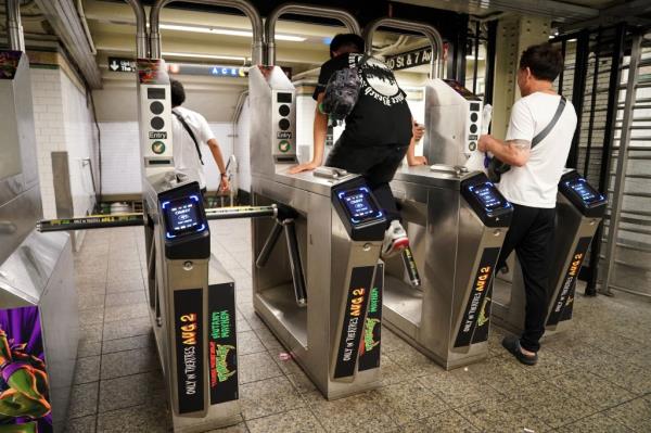 A man jumps the turnstile into the subway system earlier this year. 